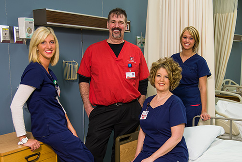 Four members of the Martin legacy family in Nursing uniforms gathered in a hospital room.
