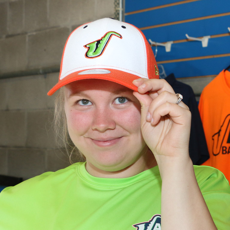 Tiani smiling and tipping her hat emblazoned with the Richmond Jazz logo.